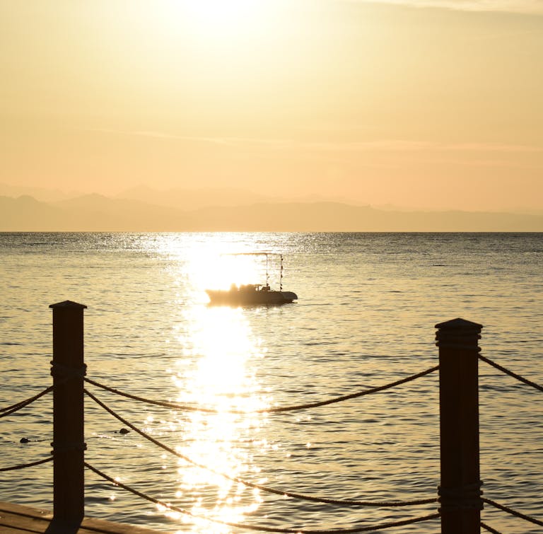 Serene view of a motorboat gliding on the sea during a sunset in Dahab, Egypt. - Remote work Dream - Dahab
